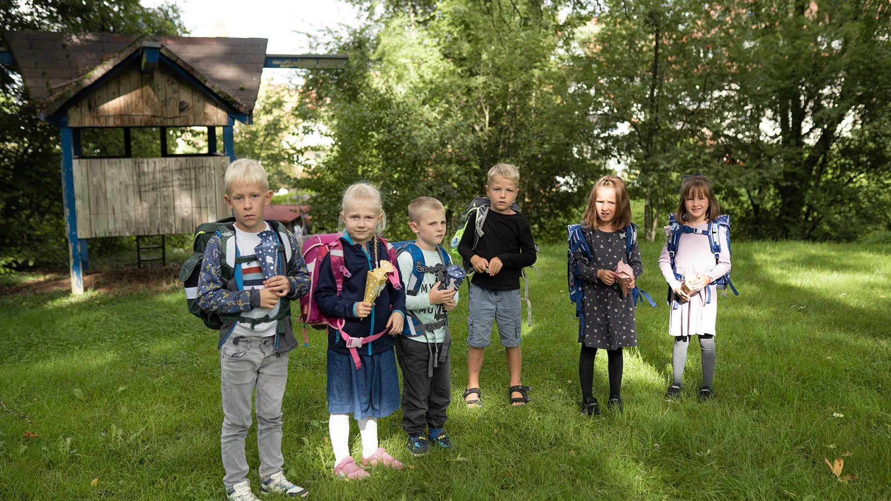 Die Erstklässler mit Schulranzen auf der Wiese beim Sommerfest